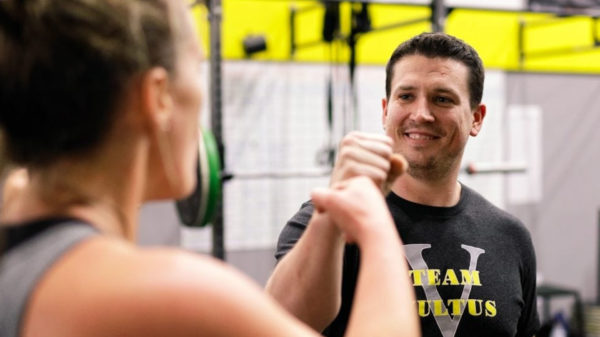 Two vultus crossfit madison wi workout buddies bumping fists after a tough set